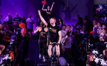 People on stationary bikes at a Cycle for Survival rare cancer fundraising event