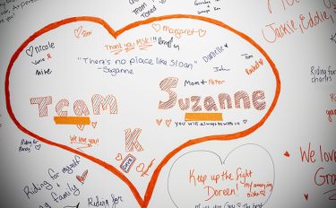 Heart-shaped messages on a wall, featuring "Team Suzanne" in bold lettering.