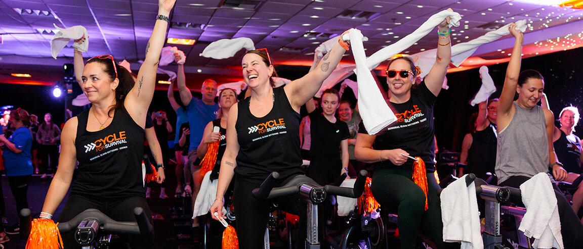 Participants wearing Cycle for Survival shirts ride stationary bikes at a fundraising event for rare cancer research at MSK.