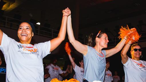 People on stationary bikes at a Cycle for Survival rare cancer fundraising event.