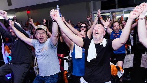 People on stationary bikes at a Cycle for Survival rare cancer fundraising event in Long Island, New York.