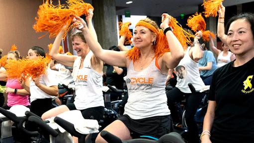 People riding stationary bikes at a Cycle for Survival rare cancer fundraising event in Palo Alto, California.