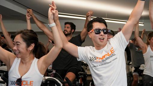 People riding stationary bikes at a Cycle for Survival rare cancer fundraising event in San Francisco.