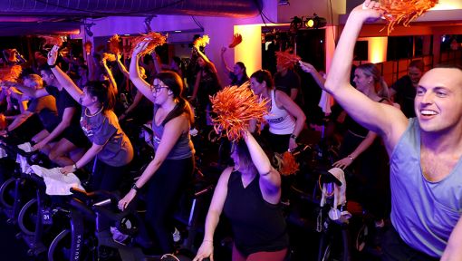 People on stationary bikes at a Cycle for Survival rare cancer fundraising event in Chicago.