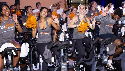 People riding stationary bikes at a Cycle for Survival rare cancer fundraising event in New York City.