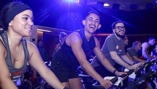 People riding stationary bikes at a Cycle for Survival rare cancer fundraising event in Los Angeles.