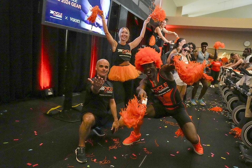 People posing and cheering at a Cycle for Survival rare cancer fundraising event in Miami.  