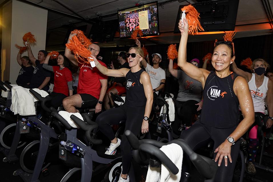 People on stationary bikes at a Cycle for Survival rare cancer fundraising event in Chicago. 