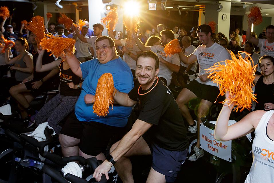 People on stationary bikes at a Cycle for Survival rare cancer fundraising event in Chicago. 