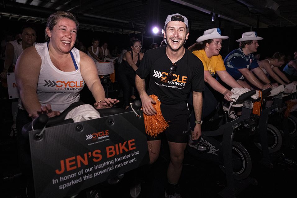 People on stationary bikes at a Cycle for Survival rare cancer fundraising event in Dallas.