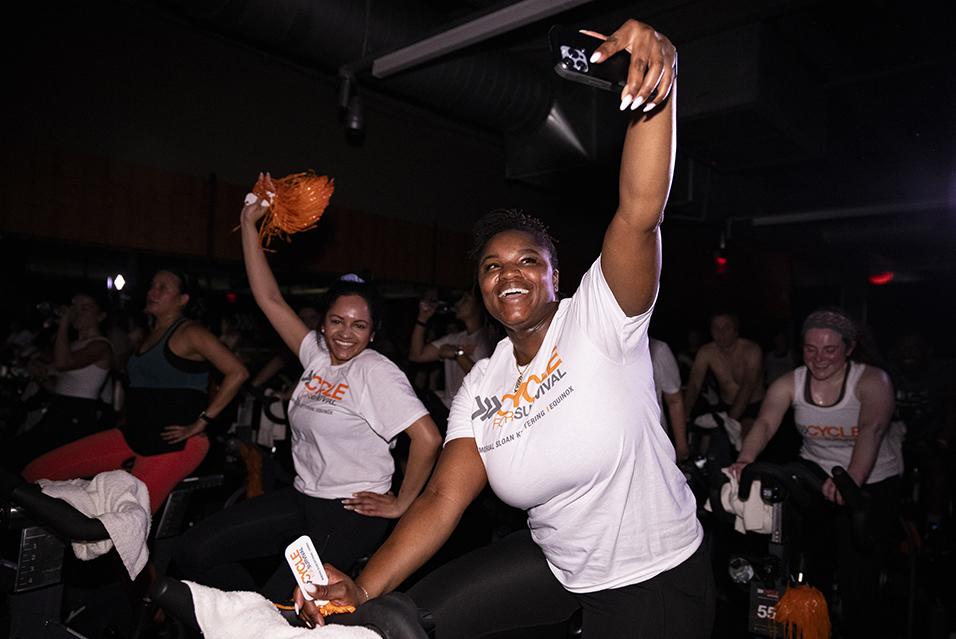 People on stationary bikes at a Cycle for Survival rare cancer fundraising event in Dallas.