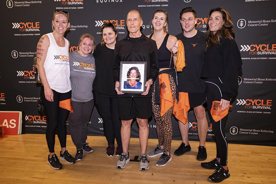 People holding signs and posing for a picture together at a Cycle for Survival rare cancer fundraising event in Dallas.