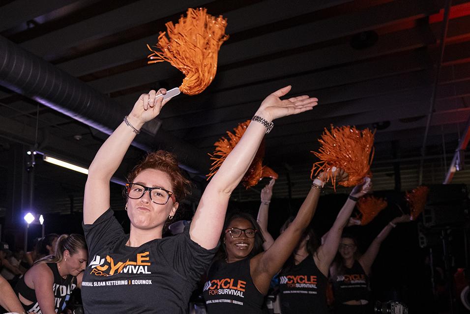 People on stationary bikes at a Cycle for Survival rare cancer fundraising event in Dallas.