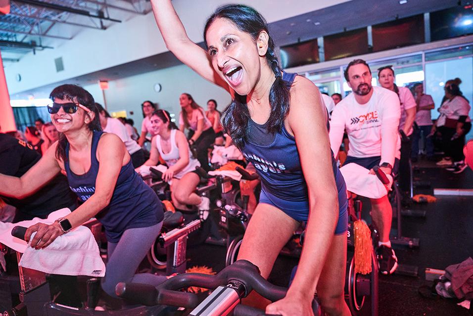 People on stationary bikes at a Cycle for Survival rare cancer fundraising event in Long Island. 