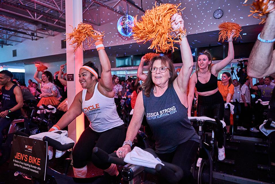 People on stationary bikes at a Cycle for Survival rare cancer fundraising event in Long Island. 