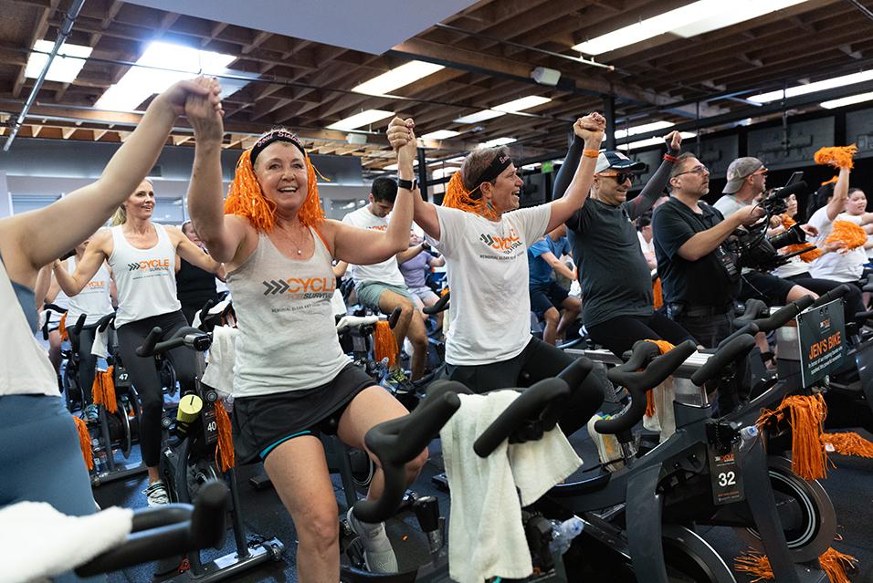 People on stationary bikes at a Cycle for Survival rare cancer fundraising event in Palo Alto.  