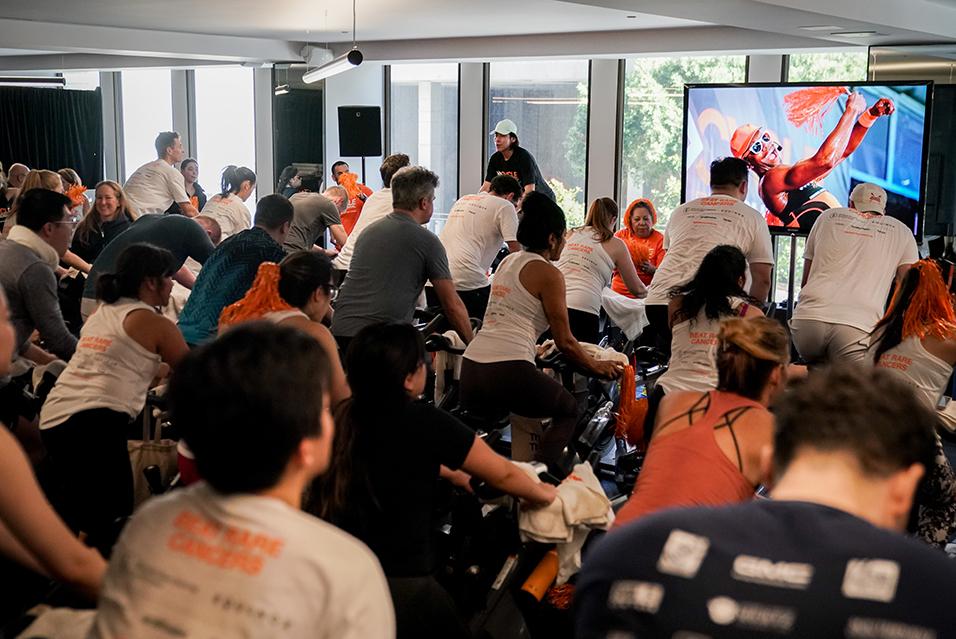 People on stationary bikes at a Cycle for Survival rare cancer fundraising event in San Francisco.  