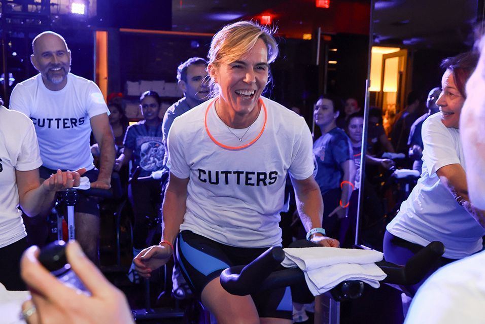 Rob and Kat Olin ride with others wearing T-shirts that read “CUTTERS” at a Cycle for Survival fundraising event. 