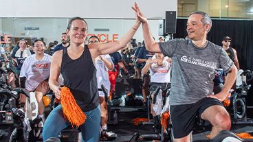 Clark Foundation team members on stationary bikes at a Cycle for Survival rare cancer fundraising ride. 