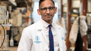 Vinod Balachandran, MD, Director of the Olayan Center for Cancer Vaccine Research at MSK, stands in an MSK lab wearing a white MSK lab coat. 