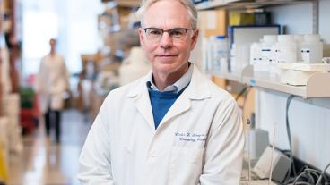 Charles Sawyers, MD, the Marie-Josée Kravis and Henry R. Kravis Chair in Human Oncology and Pathogenesis and Chair of the Human Oncology and Pathogenesis Program at MSK, stands in an MSK lab wearing a white MSK lab coat. 