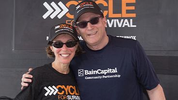 Jeannie and Jonathan Lavine standing together wearing Cycle for Survival hats.