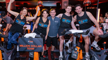 Group wearing "Team Hopp" shirts celebrating at Cycle for Survival event.