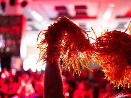 Closeup of orange pom-poms in the air at a Cycle for Survival event. 