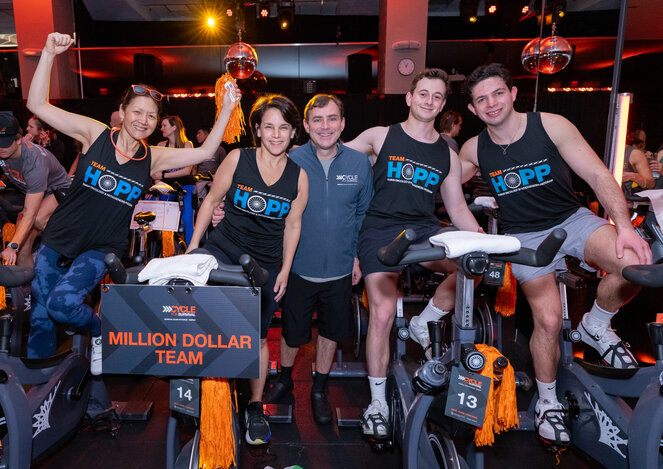 Group wearing "Team Hopp" shirts celebrating at Cycle for Survival event.